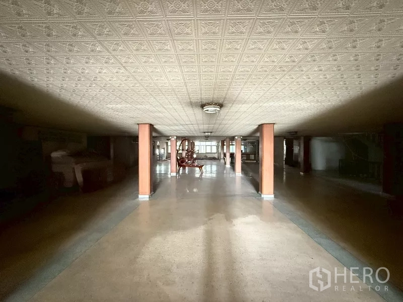 Shophouse for rent - Central view of the same hall showing tiled flooring and aligned columns.