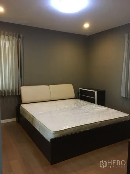 Detached House for rent or sale in Bang Kapi, Bangkok - Guest bedroom with double bed, side table and soft lighting.