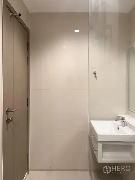 公寓 出售在Ratchathewi, Bangkok - 餐区紧邻阳台，玻璃门朝向城市景观与两把木椅。