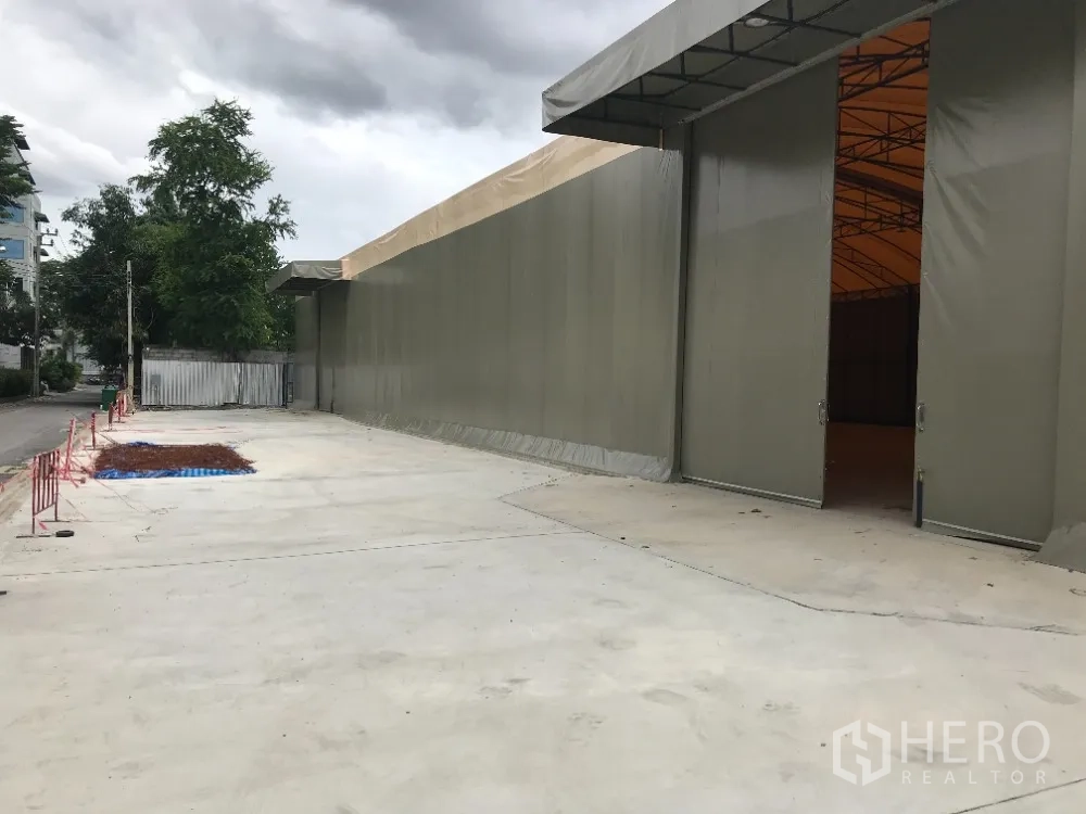 仓库 for rent in Huai Khwang, Bangkok - 大型推拉门开启，前方为卡车可通行的硬化院区。