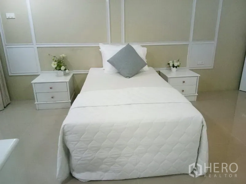 Condominium for rent in Watthana, Bangkok - Cozy third bedroom with single bed, side tables and paneled accent wall.