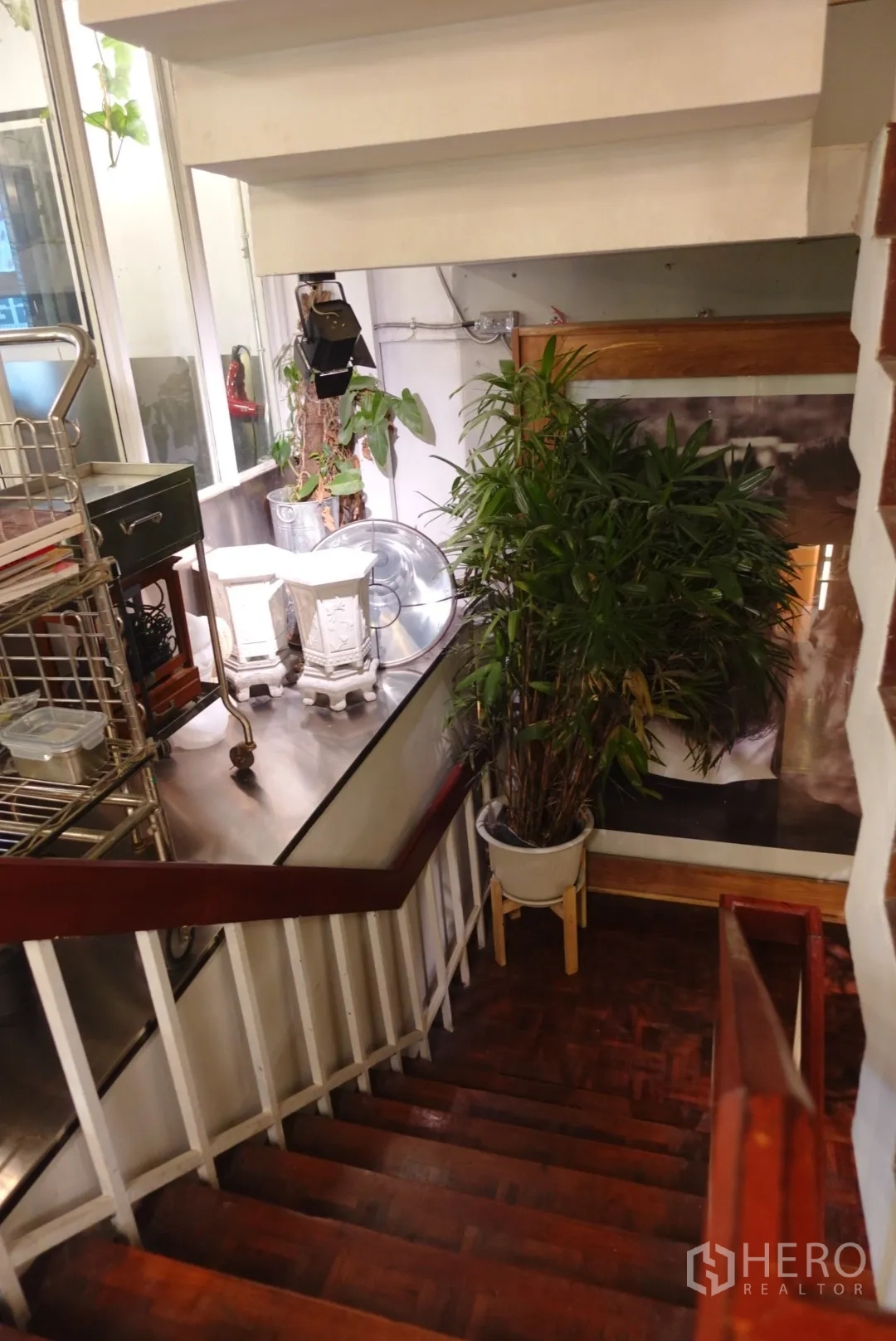 Retail Space for rent in Khlong Toei, Bangkok - Wooden staircase between floors bordered by potted plants and storage carts.
