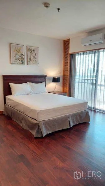 Apartment for rent - Sunlit bedroom with balcony access, wood floors and air conditioning.