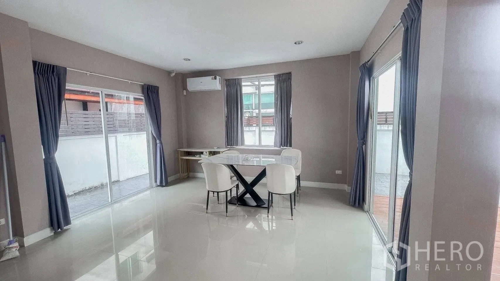 บ้านเดี่ยว for rent or sale in Saphan Sung, Bangkok - พื้นที่ทานอาหารสว่างด้วยหน้าต่างหลายด้าน พร้อมโต๊ะและเก้าอี้สี่ตัว.