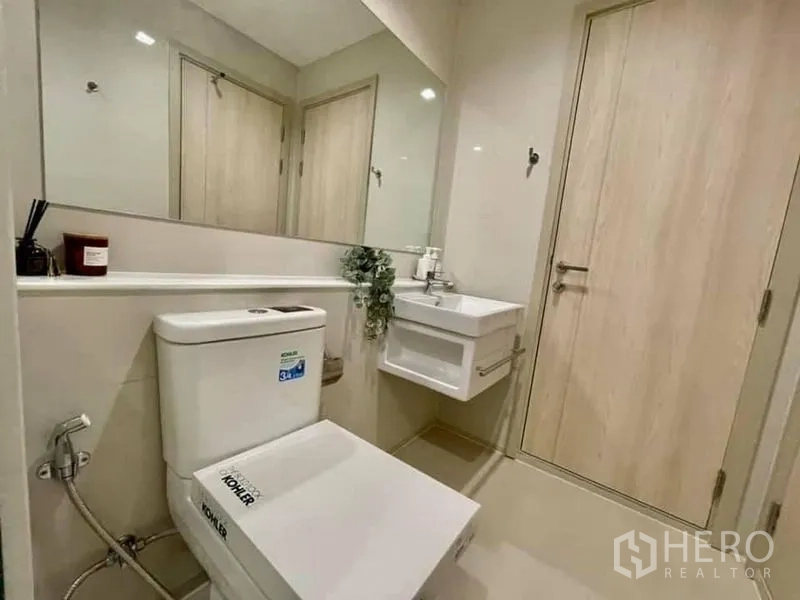 公寓 出租在Pathum Wan, Bangkok - 第二卫生间，悬空洗手台、超大镜面与科勒坐便器。