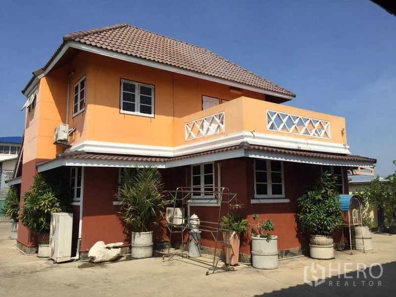 Detached House for rent or sale in Bang Bua Thong, Nonthaburi - Rear exterior highlighting second-floor terrace, tiled roof and planters around the home.
