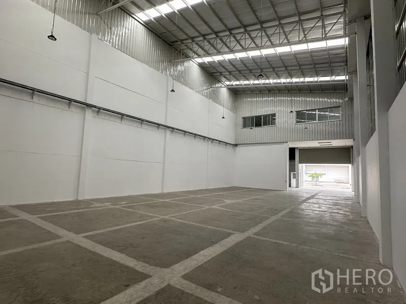 工厂 出租在Khlong Luang, Pathum Thani - 开阔厂区地面网格标线，吊灯照明齐全。
