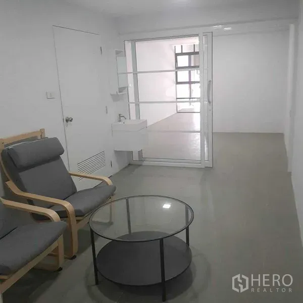 带办公室的家 出租或出售在Suan Luang, Bangkok - 小型等候区，休闲椅、玻璃圆几与推拉玻璃门。