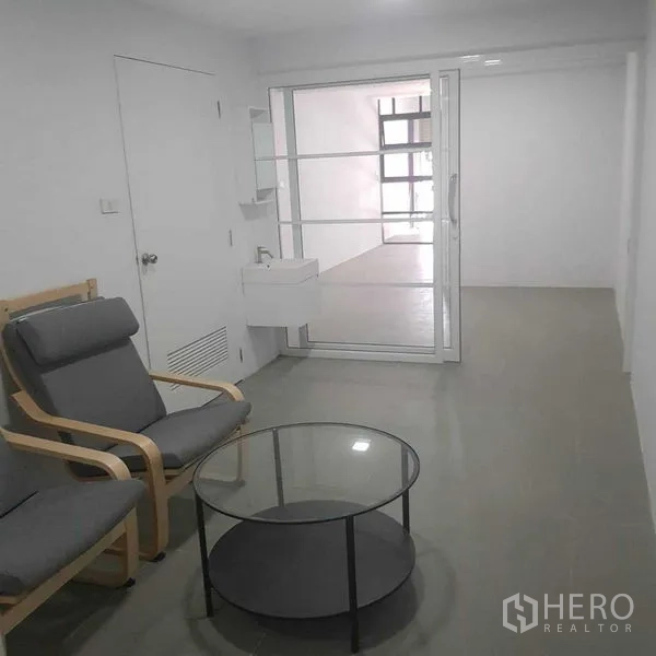 带办公室的家 出租或出售在Suan Luang, Bangkok - 小型等候区，休闲椅、玻璃圆几与推拉玻璃门。