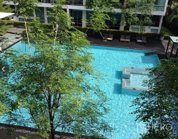 Condominium for rent in Khlong Toei, Bangkok - Condominium swimming pool with sun deck, trees and landscaped common areas.