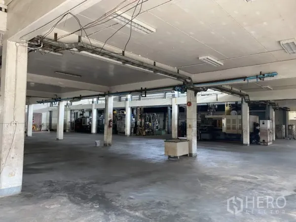 Factory for sale in Khlong Luang, Pathum Thani - Open ground-floor production space with concrete floor and structural columns.