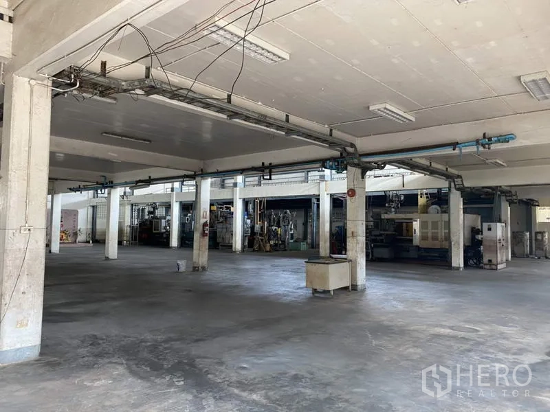 Factory for sale in Khlong Luang, Pathum Thani - Open ground-floor production space with concrete floor and structural columns.