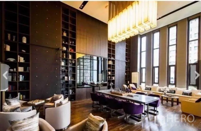 Condominium for rent in Watthana, Bangkok - Luxurious residents’ lounge with high ceilings, tall windows, bookshelves, and comfortable seating.