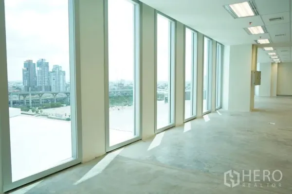 Office Space for rent in Bang Na, Bangkok - Bright open‑plan office with floor‑to‑ceiling windows and skyline views near BTS Bang Na.