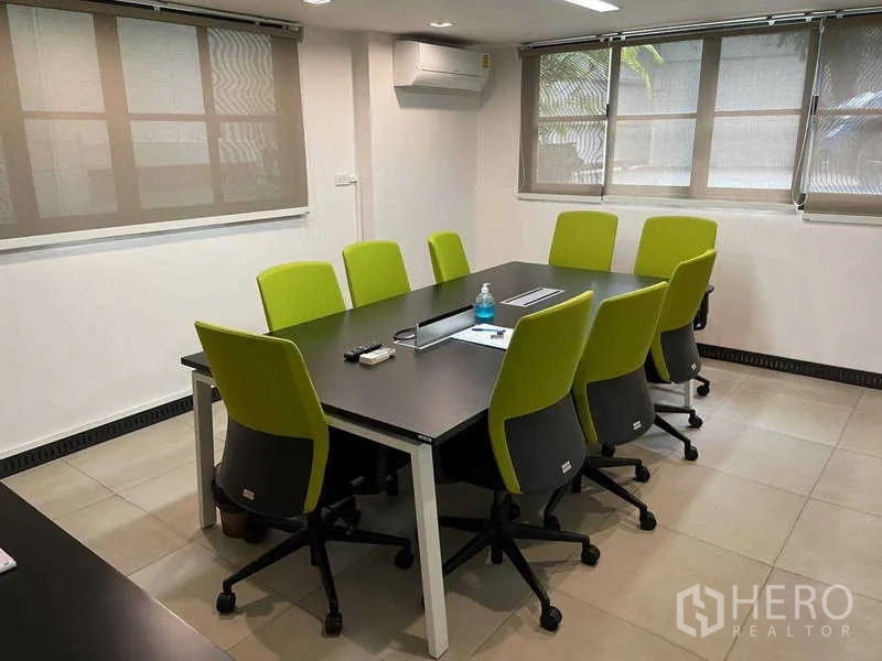 带办公室的家 出租在Watthana, Bangkok - 明亮会议室，黑色长桌与八把绿色椅子，临窗设置