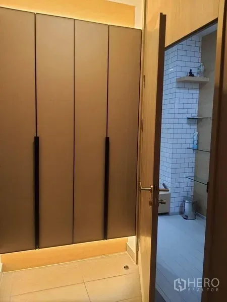 公寓 出租在Pathum Wan, Bangkok - 过道设有嵌入式衣柜，通往铺设白色地铁砖的卫浴间。