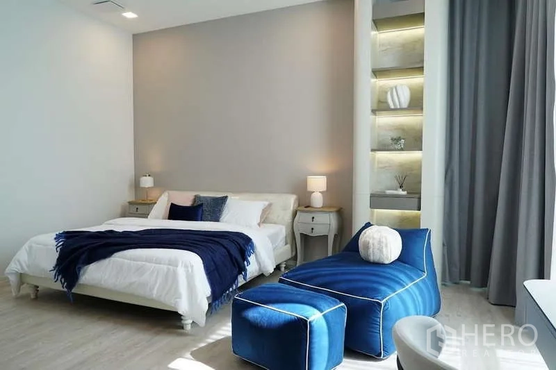 Detached House for rent in Saphan Sung, Bangkok - Bright bedroom featuring a blue chaise lounge and lighted display shelves.
