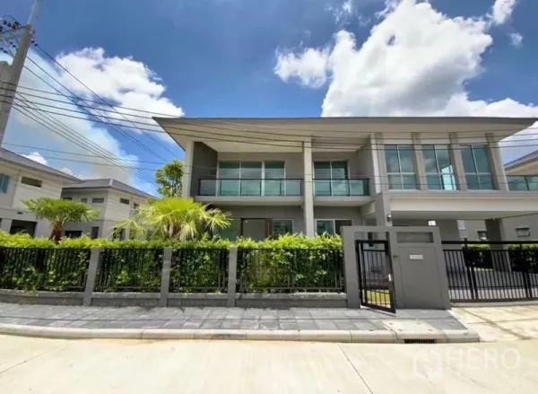 独立式住宅 出租 - 当代风格独栋别墅正面，修剪整齐的绿篱与大门。