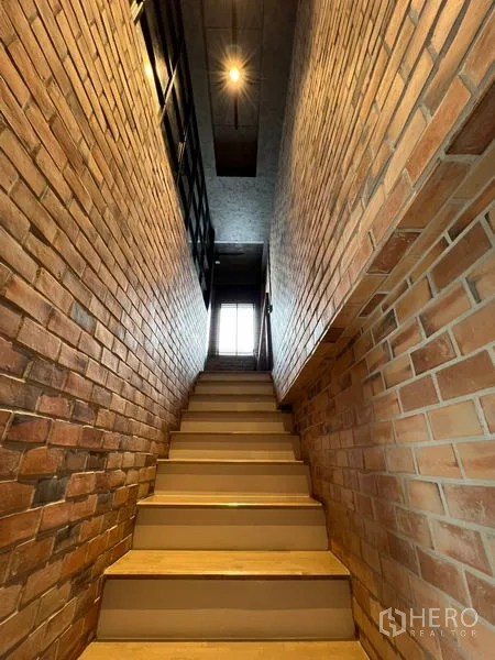 Townhouse for rent in Saphan Sung, Bangkok - Stairwell lined with exposed brick leading to the upper floor.