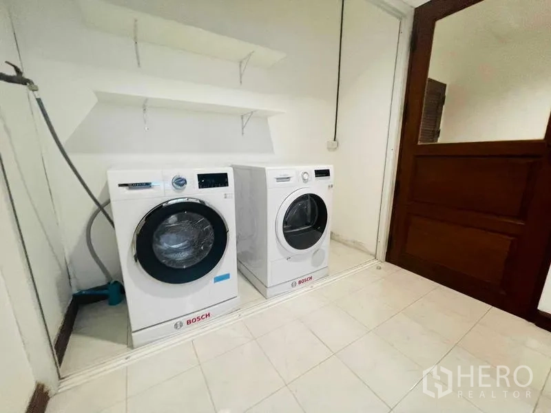 Condominium for rent - Laundry room with Bosch front-load washer and dryer beneath wall shelves.
