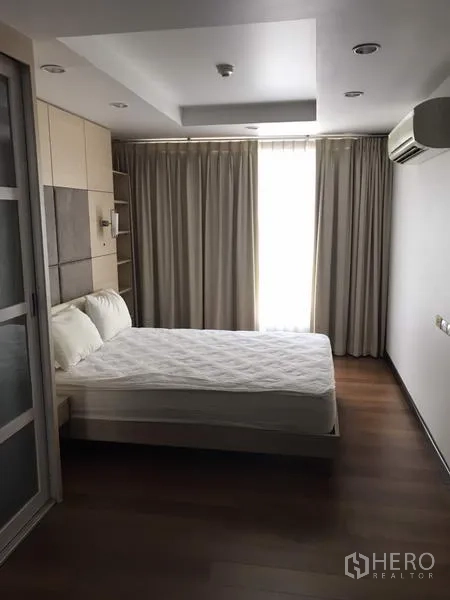 公寓 出租在Watthana, Bangkok - 卧室设大床、木地板、遮光窗帘、嵌灯与推拉衣柜。