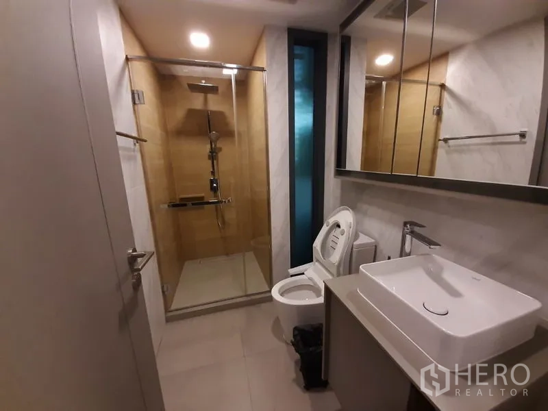 公寓 出租或出售在Watthana, Bangkok - 现代卫浴，设大镜面、台上盆与玻璃淋浴房。