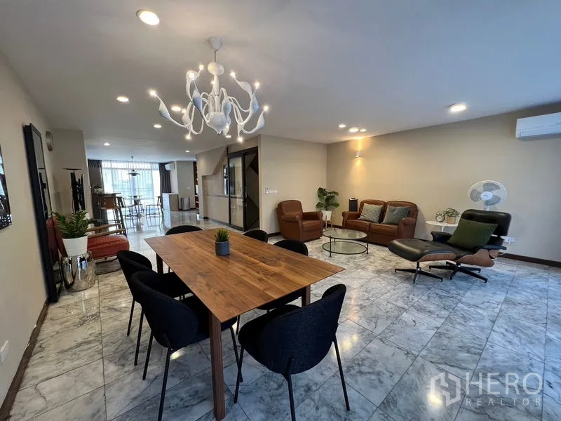 Townhouse for rent or sale in Suan Luang, Bangkok - Open-plan living and dining room with marble flooring, wooden table, leather sofas and a modern chandelier.