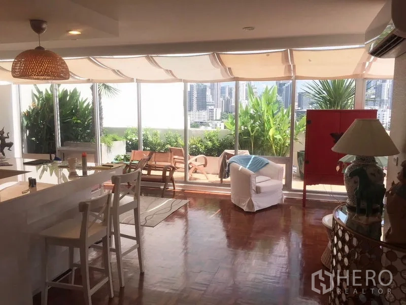 公寓 出租在Khlong Toei, Bangkok - 开放式客厅连接露台，落地窗带来绿植与曼谷天际线景观。