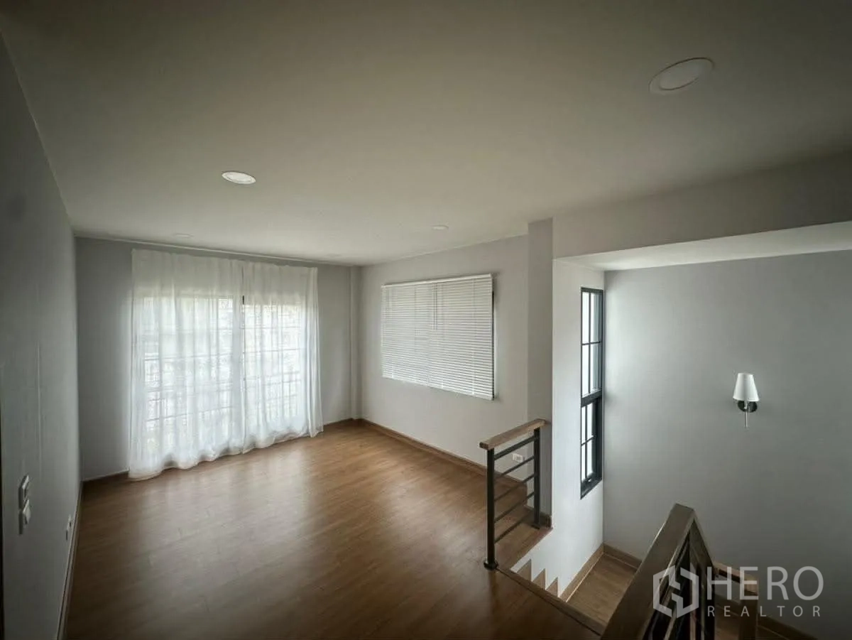 独栋房屋 for rent in Bang Phli, Samut Prakan - 二层过厅铺木地板，大窗与轻薄窗帘采光充足。