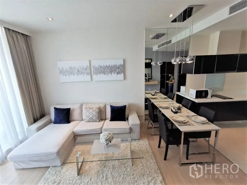 คอนโด ให้เช่าในWatthana, Bangkok - โถงนั่งเล่นและรับประทานอาหารแบบโอเพ่นแพลน โซฟามุม โต๊ะกลางกระจก และโคมไฟแขวน