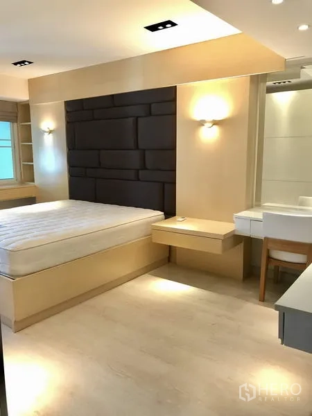 Condominium for rent in Watthana, Bangkok - Dining area under a white chandelier facing the TV wall and sofa in an open-plan space.