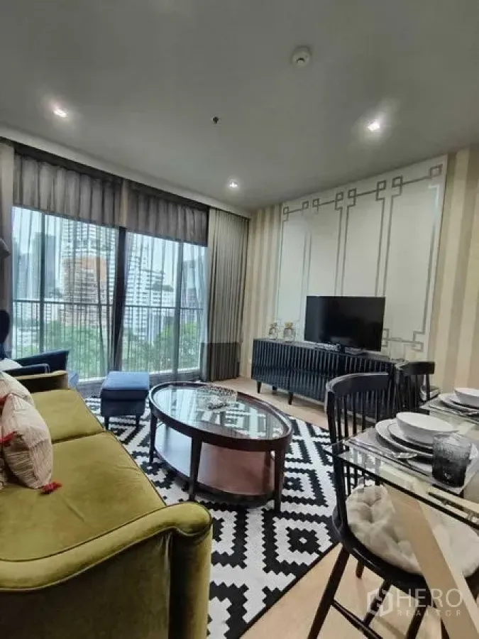 公寓 出租在Bangkok - 客餐厅面向阳台，设有电视与餐桌，透过全高窗帘采光充足。