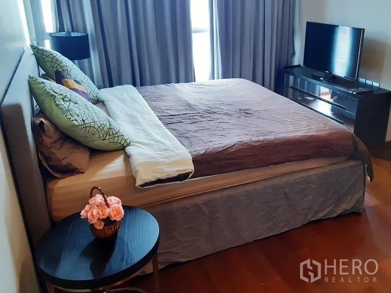 公寓 出租在Watthana, Bangkok - 次卧配双人床、床边桌与电视柜，临窗而设。