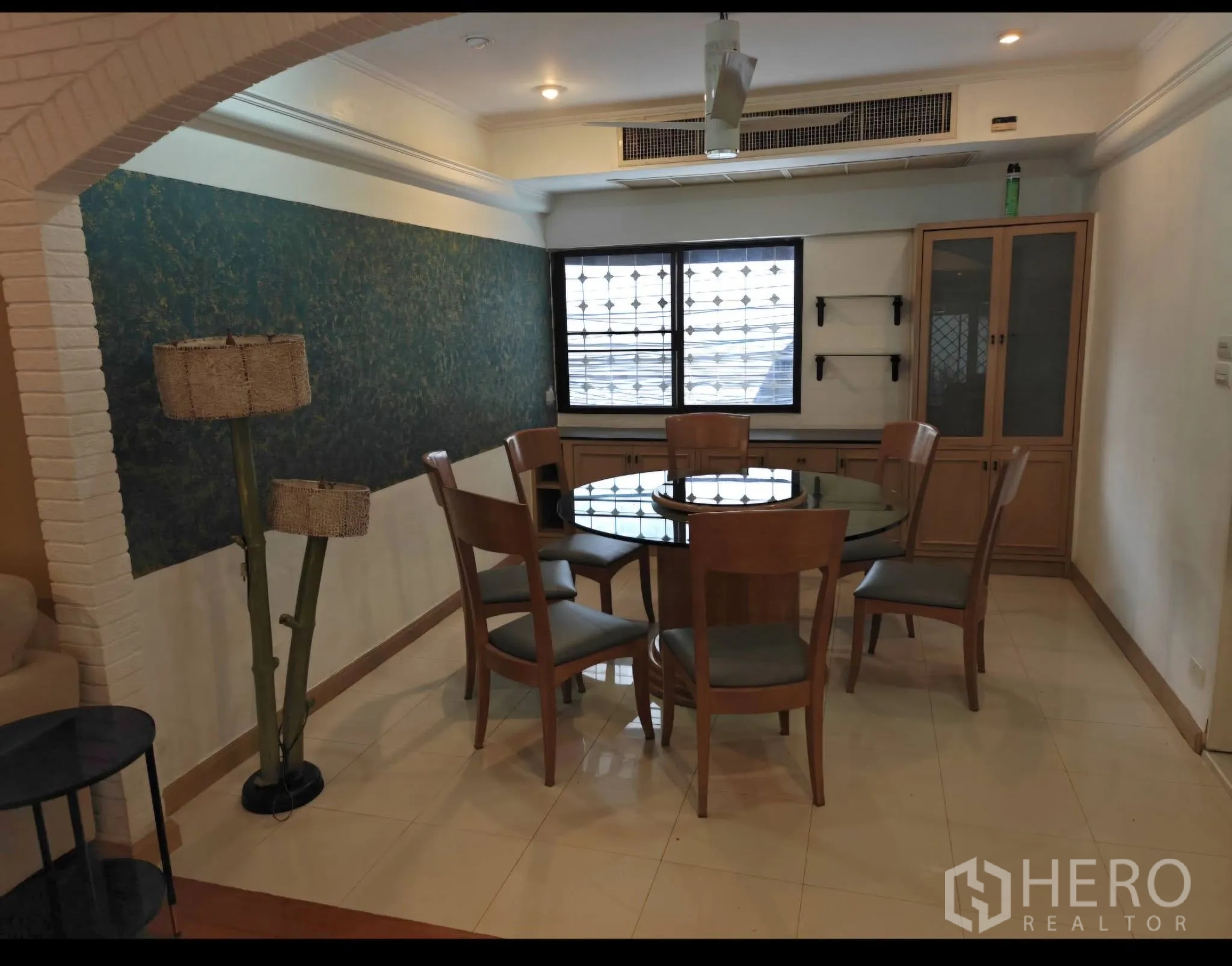 公寓 for rent in Sathon, Bangkok - 餐区配圆形玻璃餐桌六椅、内置柜与特色墙面。