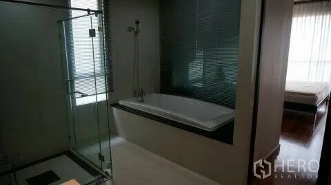 Condominium for rent or sale in Pathum Wan, Bangkok - Ensuite bathroom with a built-in bathtub beside a glass shower, view toward the bedroom