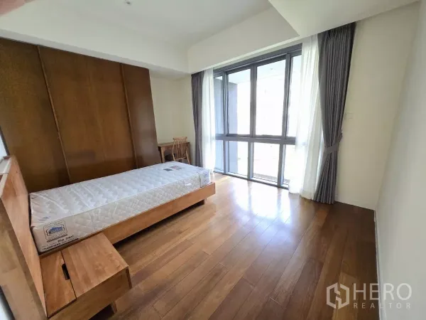 公寓 出租在Yan Nawa, Bangkok - 明亮卧室，单人床与内置木质家具，配大窗与窗帘。