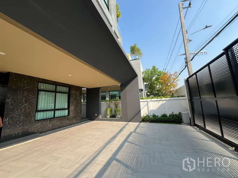 บ้าน ขายในSuan Luang, Bangkok - ที่จอดรถในร่มและลานปูกระเบื้องหลังประตูรั้ว