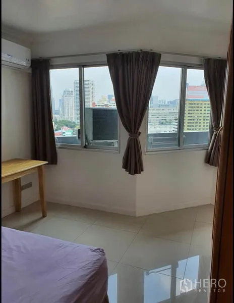 公寓 出租在Ratchathewi, Bangkok - 卧室转角窗配窗帘，可览城市天际线。