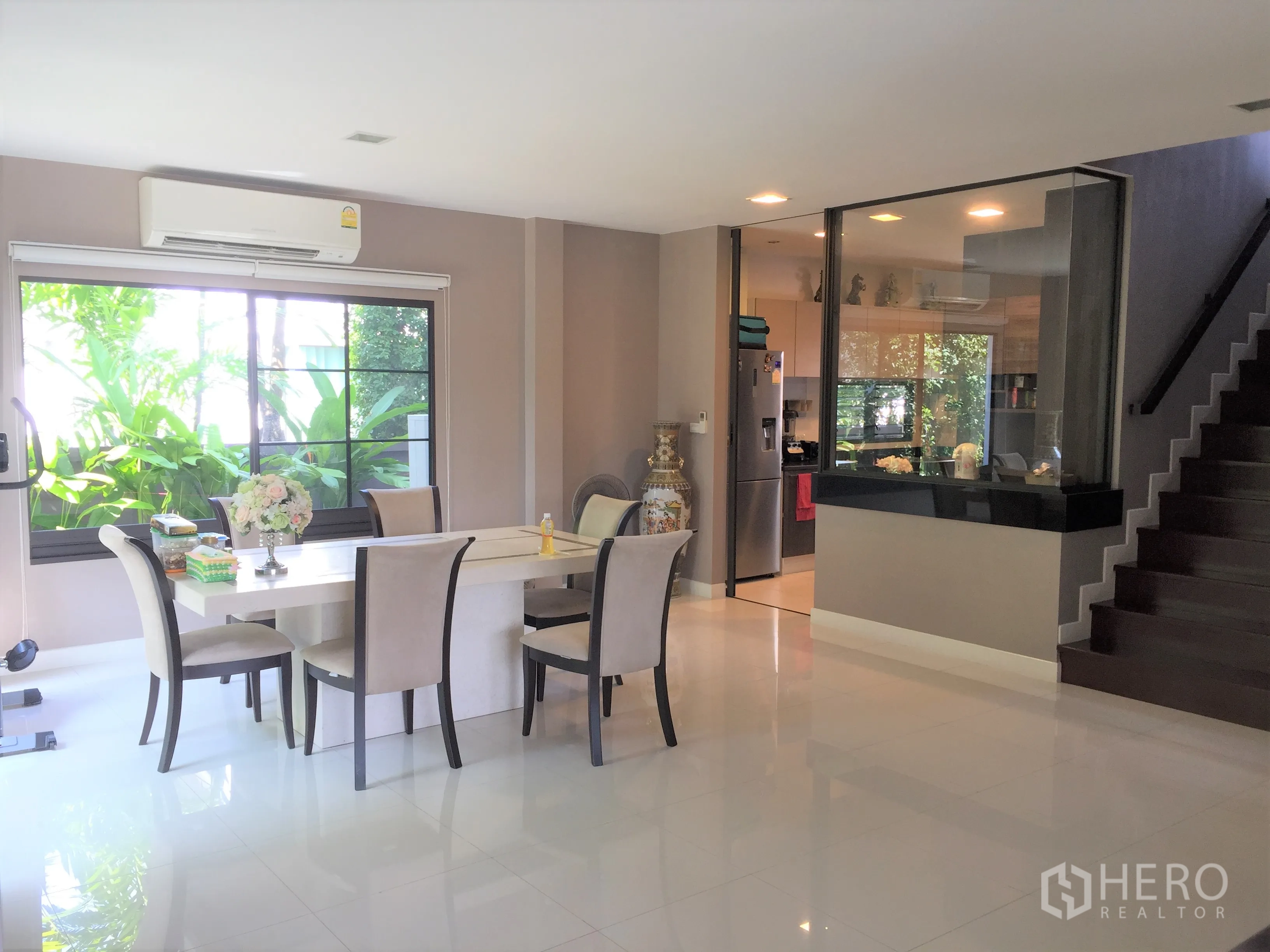 独立式住宅 出租或出售在Prawet, Bangkok - 餐区连接玻璃隔断厨房与楼梯，室内采光充足并配空调。