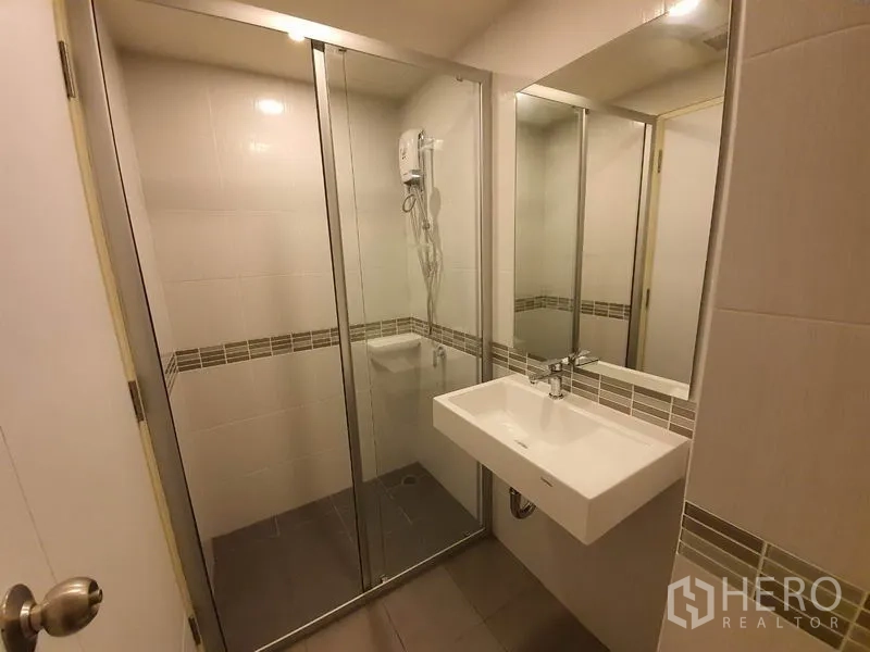 公寓 出售在Chatuchak, Bangkok - 卫浴镜柜与玻璃淋浴间，线条简洁。