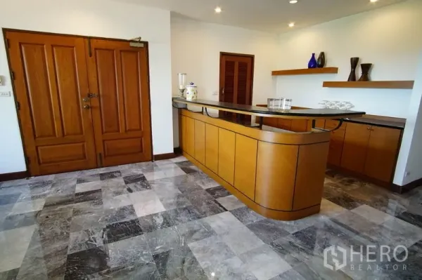 Apartment for rent in Watthana, Bangkok - Entrance foyer featuring double wooden doors and a curved built-in bar counter with shelving.