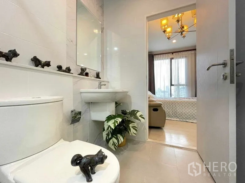公寓 出售在Huai Khwang, Bangkok - 整洁浴室，大片镜面与盆栽，通向卧室。