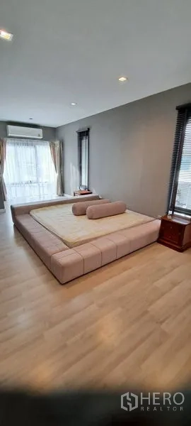 Detached House for rent in Lat Krabang, Bangkok - Spacious master bedroom with platform bed, wood flooring and floor-to-ceiling windows