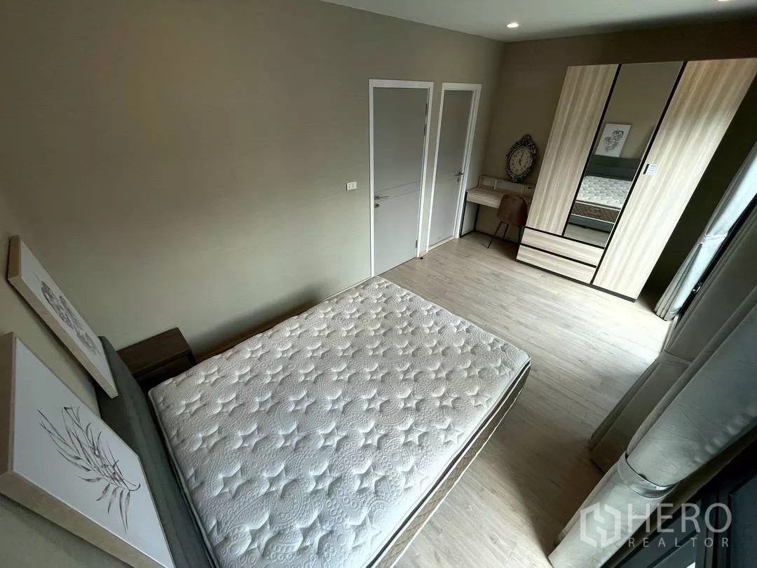 Townhouse for rent in Suan Luang, Bangkok - Bedroom with bed, built-in wardrobe, vanity desk and doors to storage and ensuite.