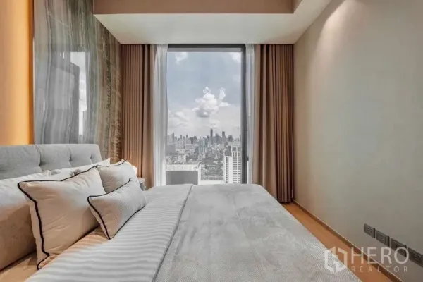 Condominium for rent or sale in Pathum Wan, Bangkok - Bedroom with a large window showcasing a wide Bangkok skyline view.