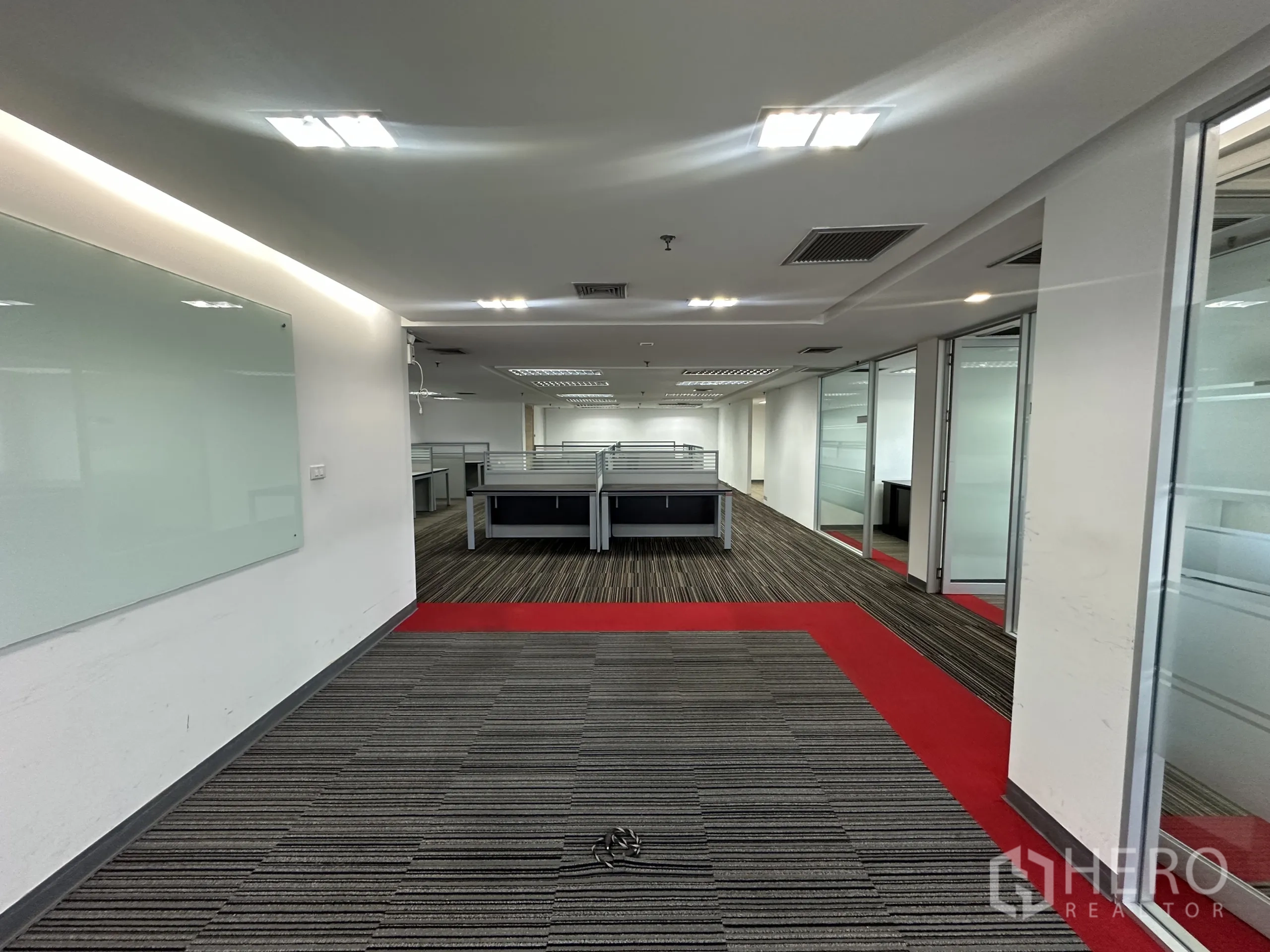 办公空间 出租在Watthana, Bangkok - 通往工位的走廊，玻璃会议室与红色地毯点缀
