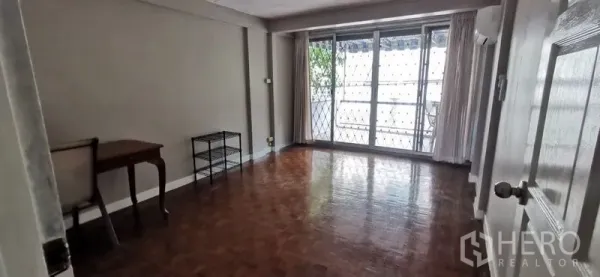 联排别墅 出租在Watthana, Bangkok - 宽敞客厅，拼花木地板，推拉门通向带防盗栏的阳台