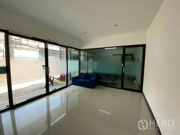 Factory for rent in Phra Pradaeng, Samut Prakan - Bright glass-walled office area inside the factory complex with tiled floors and a small seating zone.