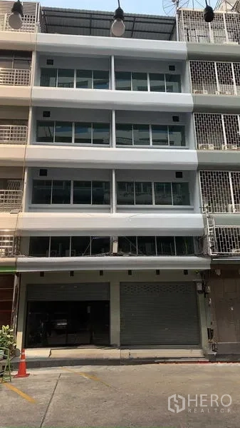 Office Space for rent in Bang Rak, Bangkok - Front exterior of a multi-storey office shophouse with wide glass windows and a ground-floor roller shutter in Bang Rak.