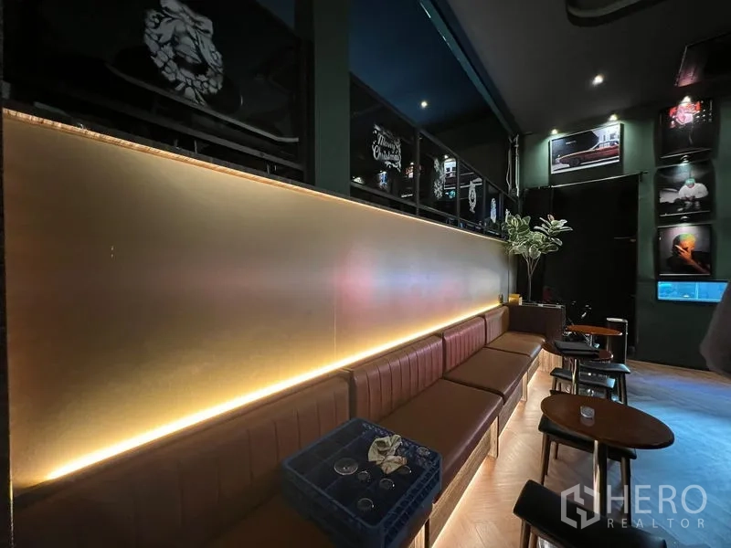 พื้นที่ขายปลีก ให้เช่าในWatthana, Bangkok - ที่นั่งบูธหนังสีน้ำตาลริมผนัง พร้อมไฟเส้นอบอุ่นและโต๊ะเล็ก
